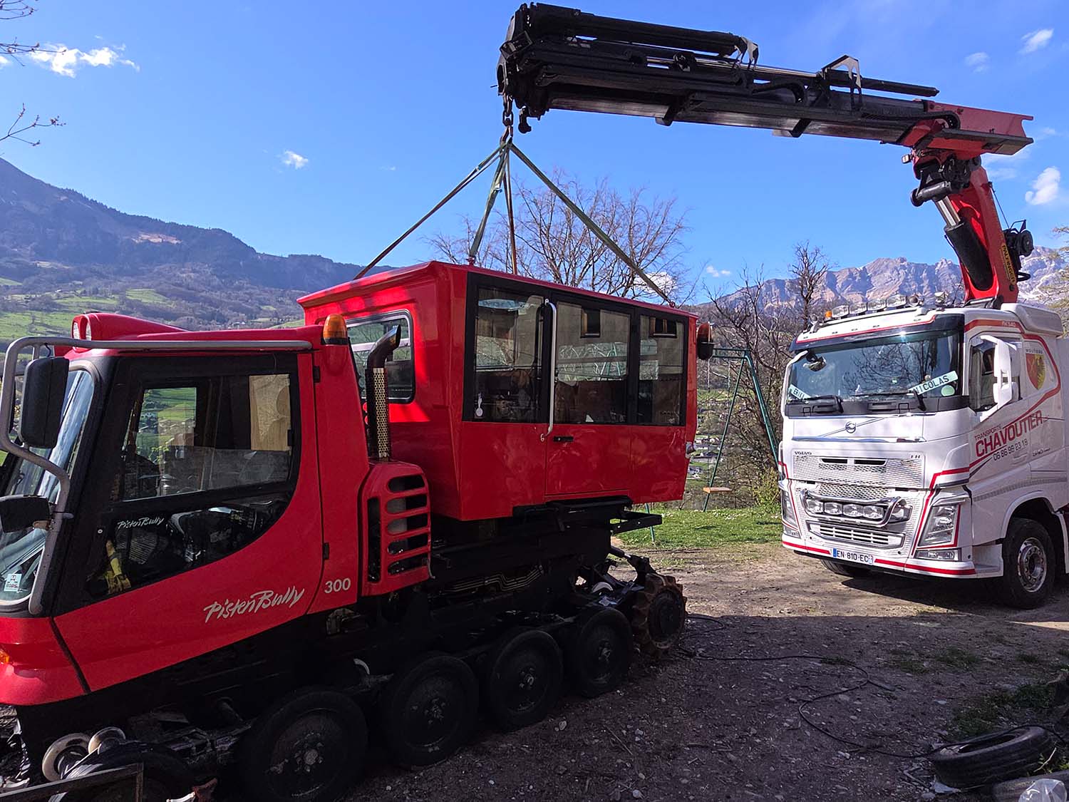 photo d'un camion grue entrain d'installer la cabine d'une dameuse
