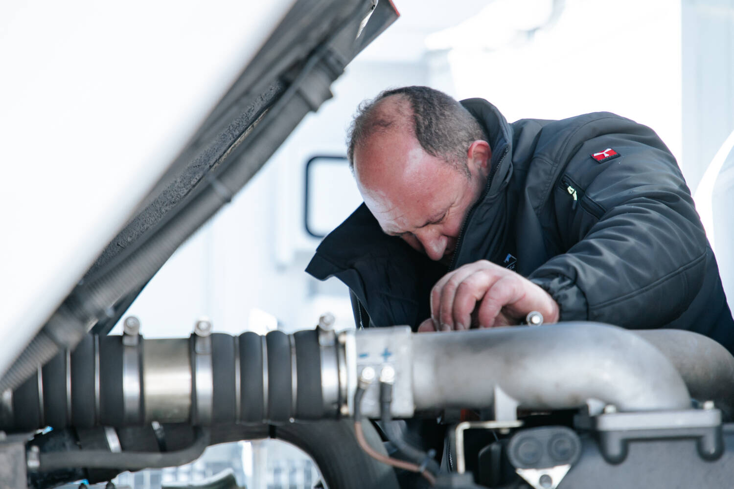 Gérald entrain de réaliser la maintenance d'une dameuse dans les Alpes