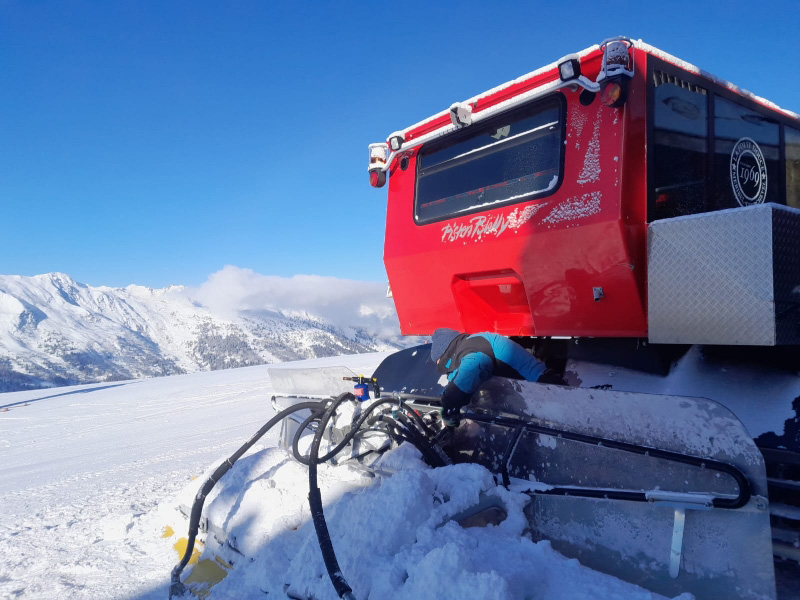photo d'une dameuse rouge sur les pistes de ski