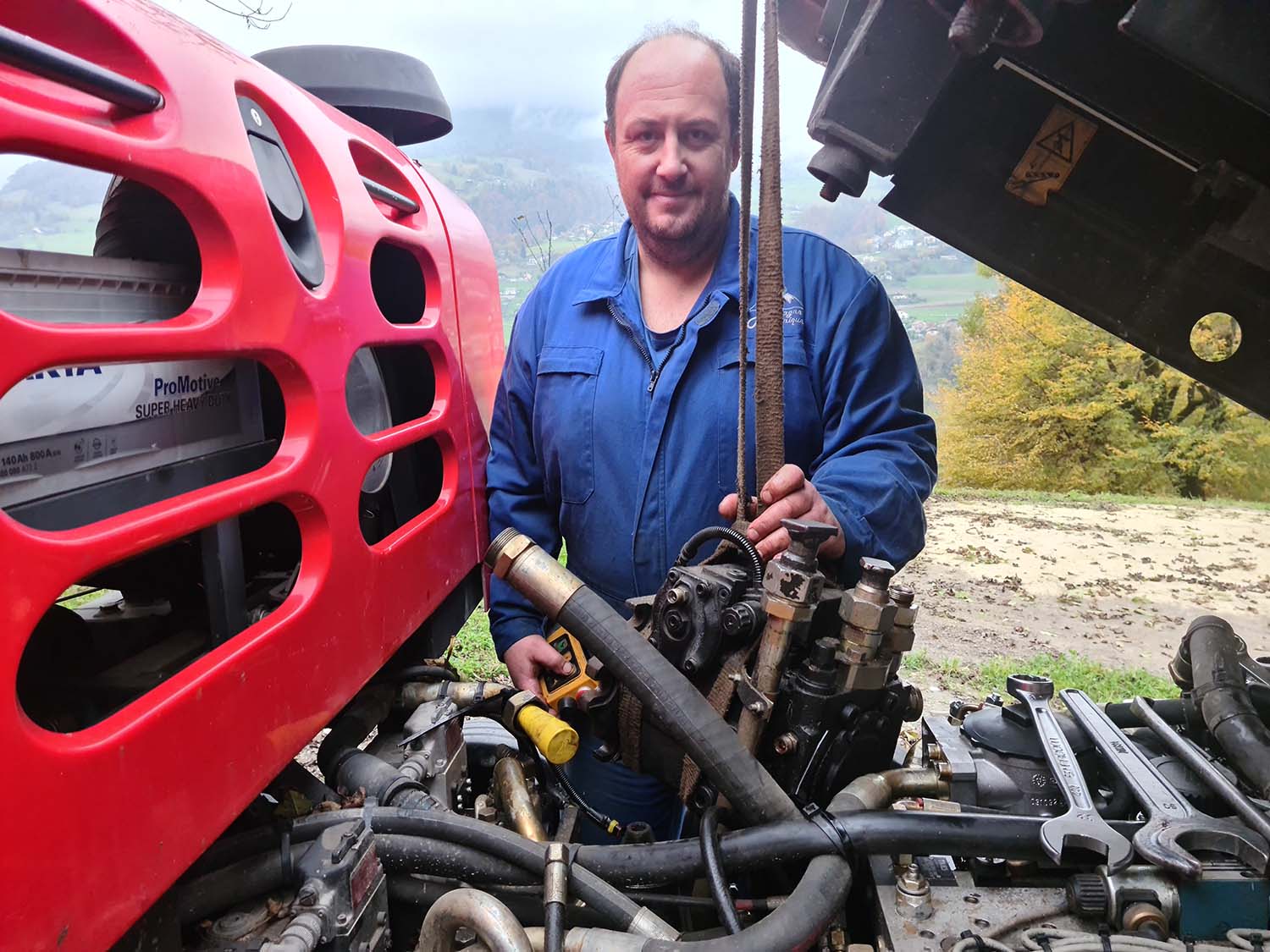 Photo de Gérald entrain de réaliser la maintenance d'une dameuse dans les Alpes