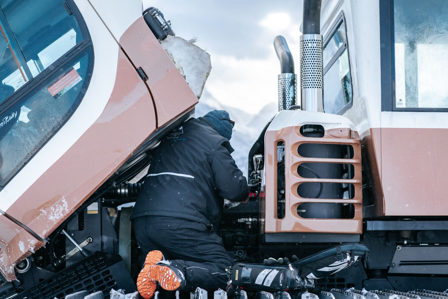 photo de Gérald, gérant de Montagne Mécanique entrain de réparer une dameuse